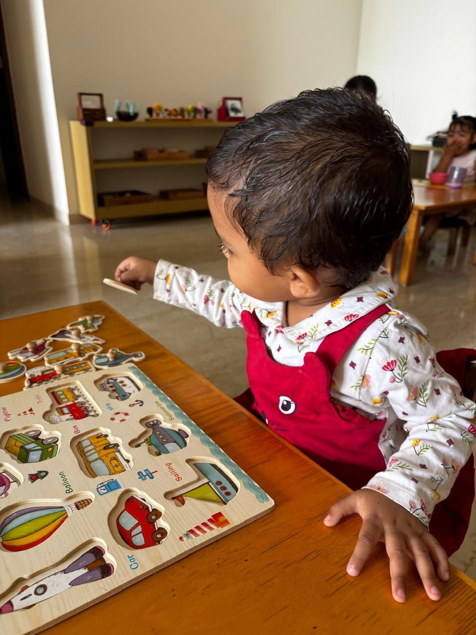 Toddler exploring a wooden vehicles peg puzzle