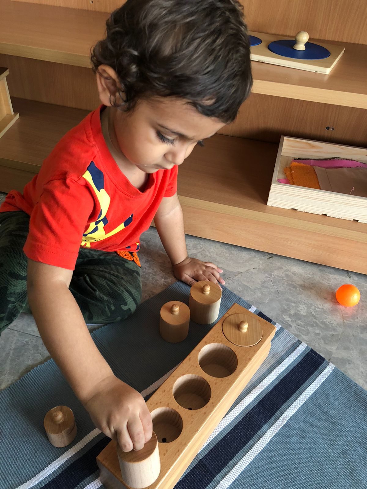 Toddler working with Montessori knobbed cylinders